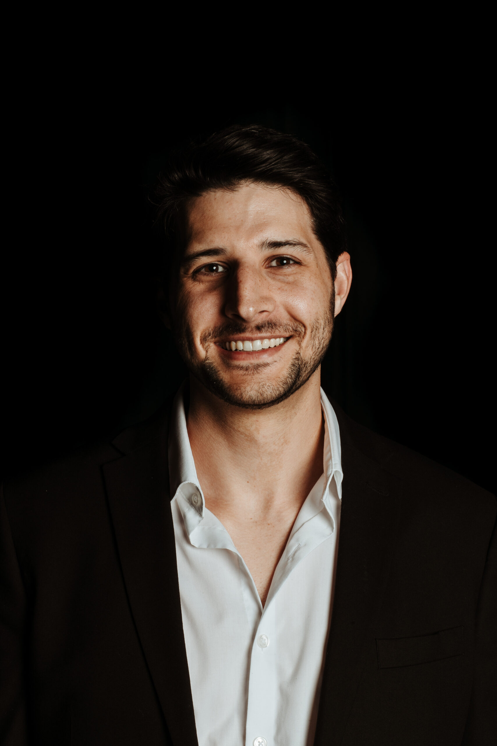 A man in a suit smiling for the camera.